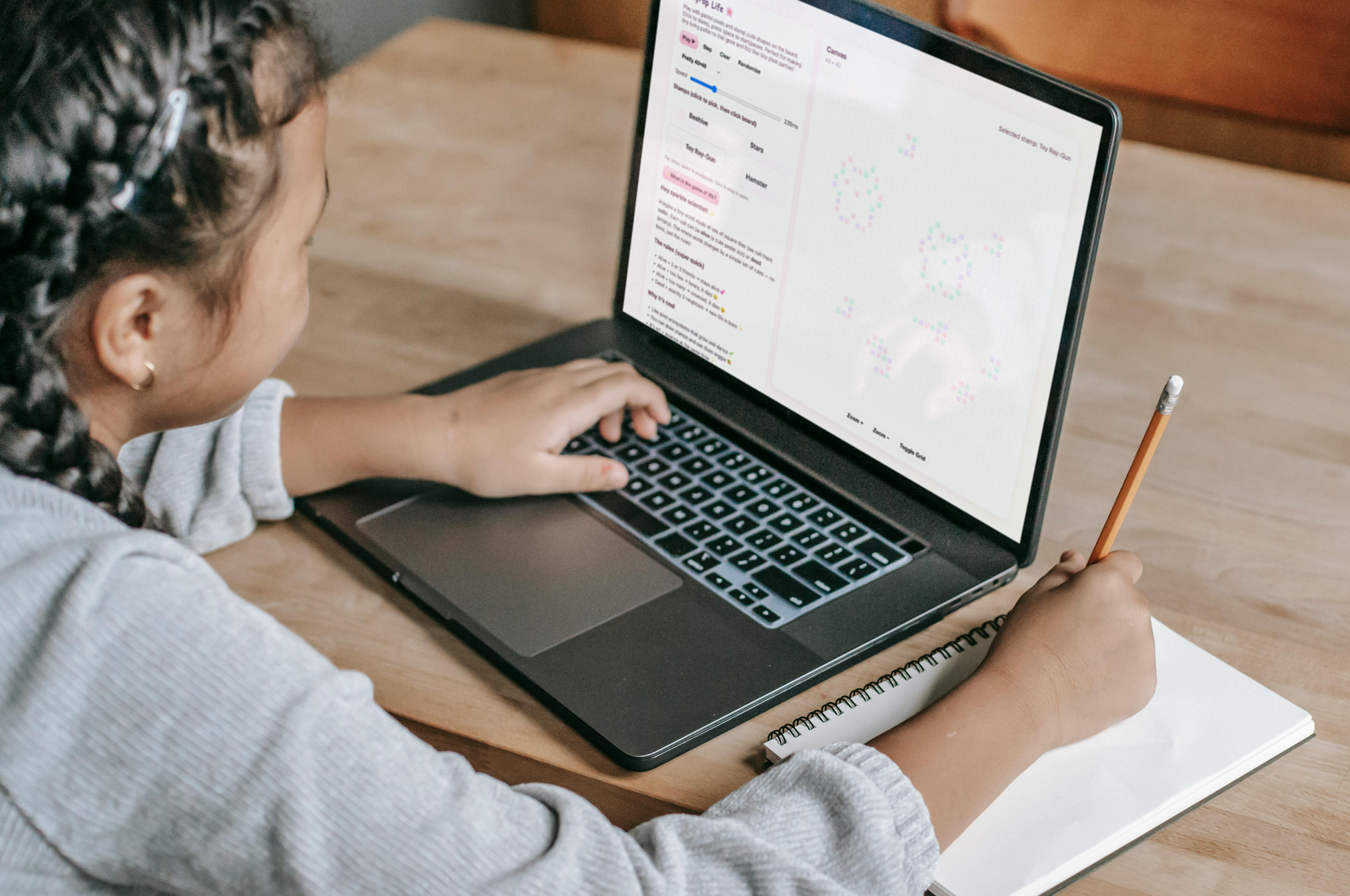 Image of girl of 8 years old for a computer showing a pastel screen of square dots with on the left text, play buttons, stamps and paragraph of text.